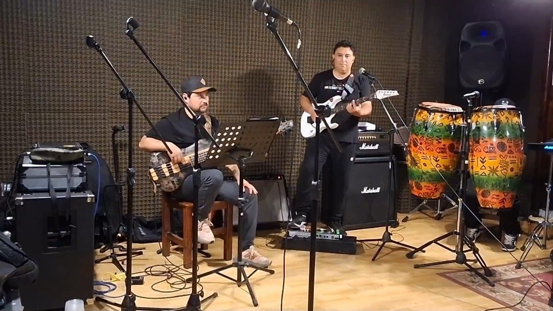 Ensayo de la banda en estudio con bajo, guitarra y congas