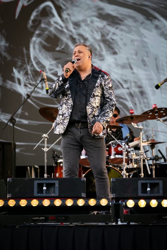Vocalista de Entretiempos cantando en un escenario al aire libre